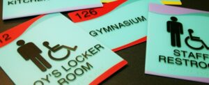 Acrylic and photopolymer signs still dominate the ADA signage market—which would be the preferred materials in many sign specifications? Read about the applications of each material and how it can affect your signage.